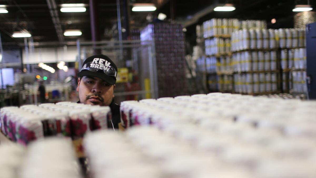 A worker loads cans of beer onto a pallet at the brewery production facility of Revolution Brewing in Chicago in 2014.