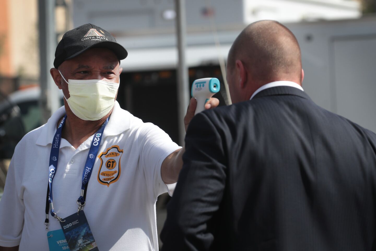 A worker has his temperature taken before entering the security perimeter outside the Wisconsin Center, where the Democratic National Convention began Monday in Milwaukee.