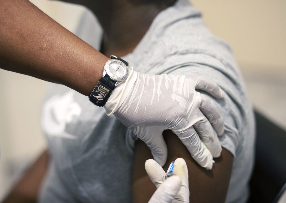 Sisi Ndebele receives a seasonal influenza vaccine from a nurse at a pharmacy clinic in Johannesburg, South Africa. 
