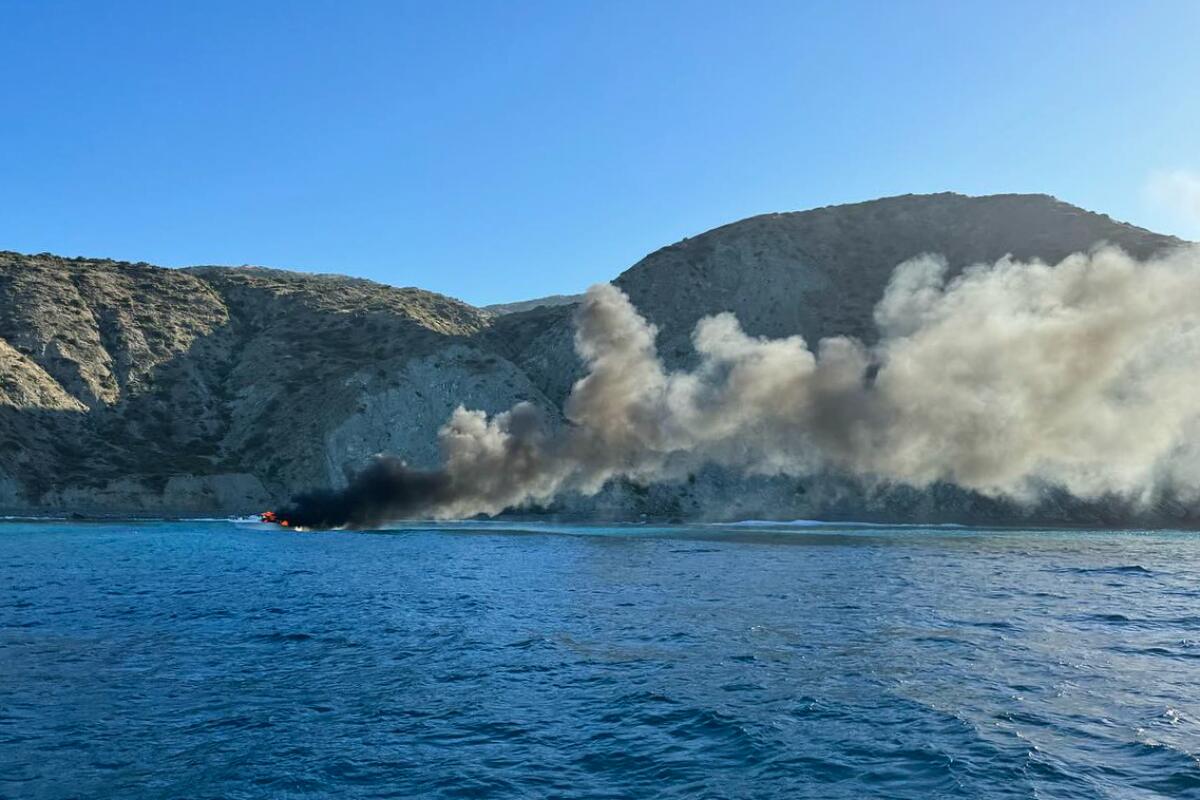 Smoke pours from a burning boat.