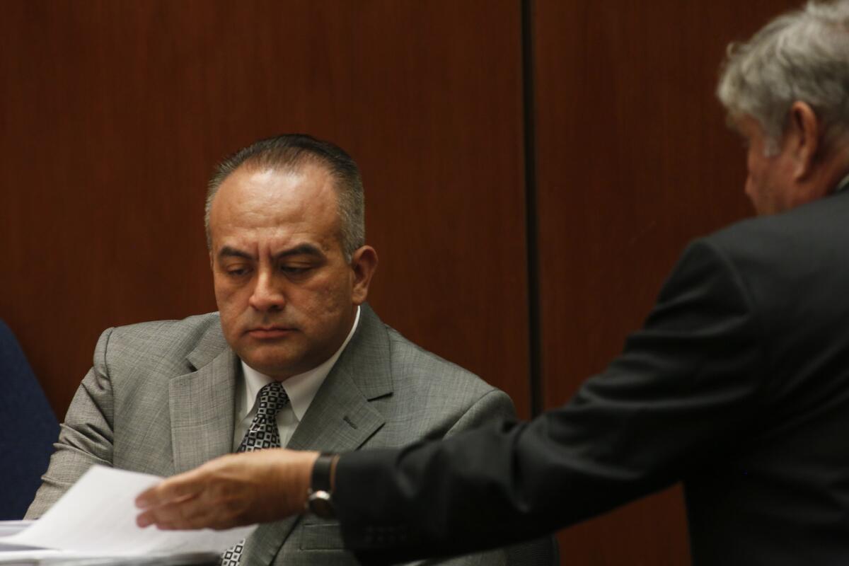 California Assemblyman Raul Bocanegra (D-Pacoima), left, is shown a document by defense attorney Richard P. Lasting during the perjury and voter fraud trial of Richard Alarcon and his wife, Flora Montes de Oca Alarcon, in Los Angeles District Court on Tuesday.