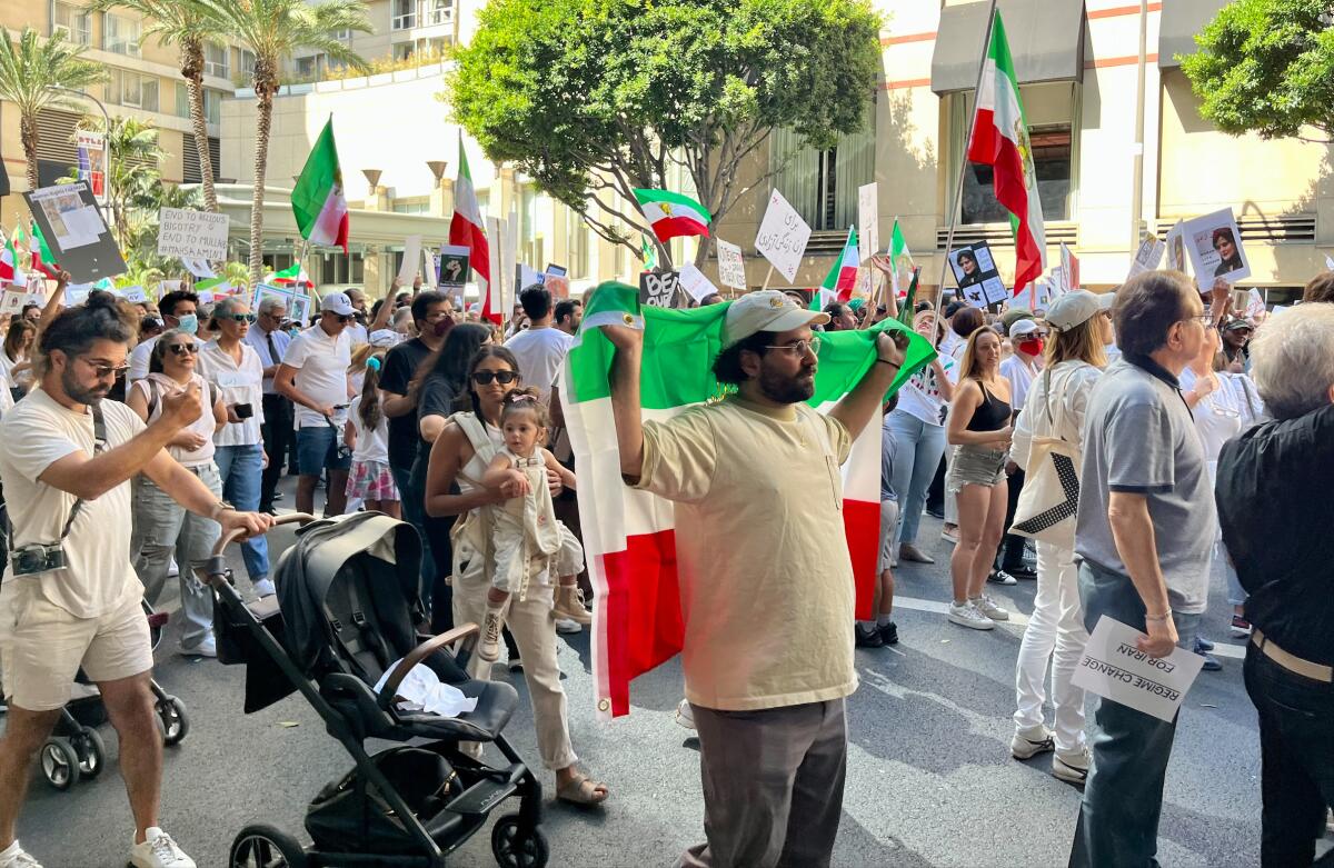 Demonstrators in Pershing Square, some with Iranian flags