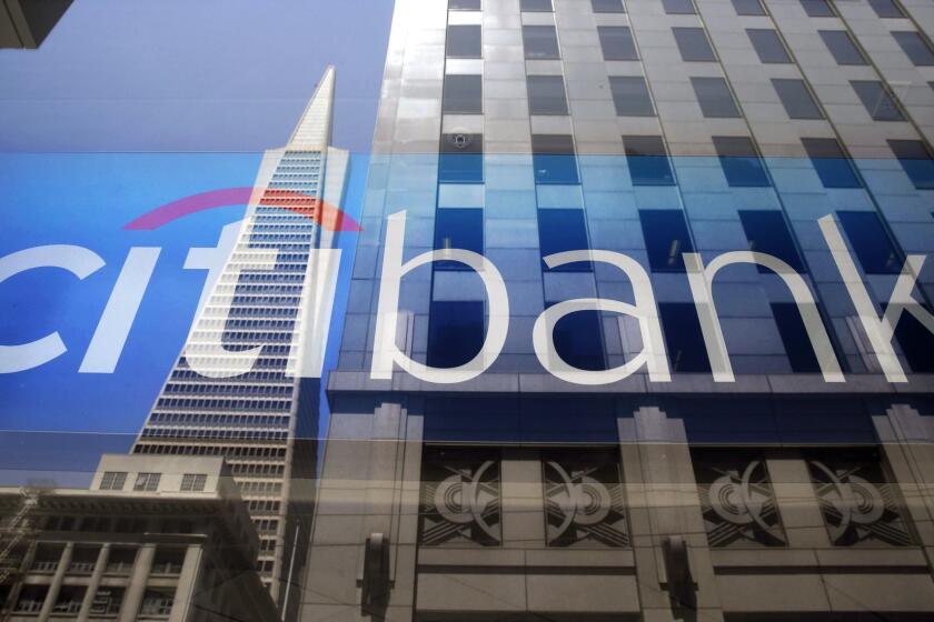 The Transamerica Pyramid is reflected in the window of the main branch of Citibank in the Financial District of San Francisco, in this file photo. Citigroup is selling its subprime lender, OneMain Financial, to Springleaf.