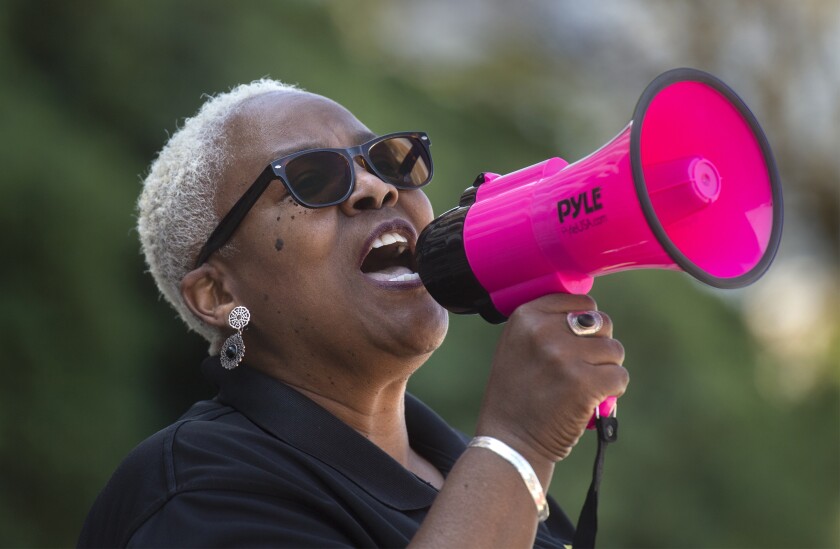 Rev. Trena Turner uses a megaphone to lead a group of protesters in a chant in front of City Hall in Stockton, Calif., on April 3, 2021. The group was protesting the police beating of 17-year-old Devin Carter on Dec. 30. (Clifford Oto/The Record via AP)
