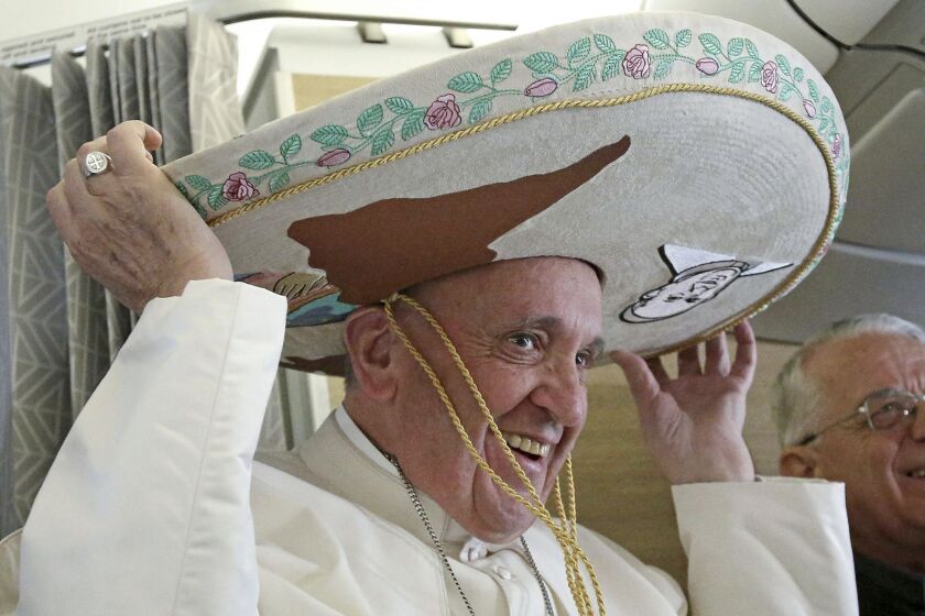 Pope Francis wears a traditional Mexican sombrero he received as a gift from a journalist aboard the plane during the flight from Rome to Havana, Cuba.