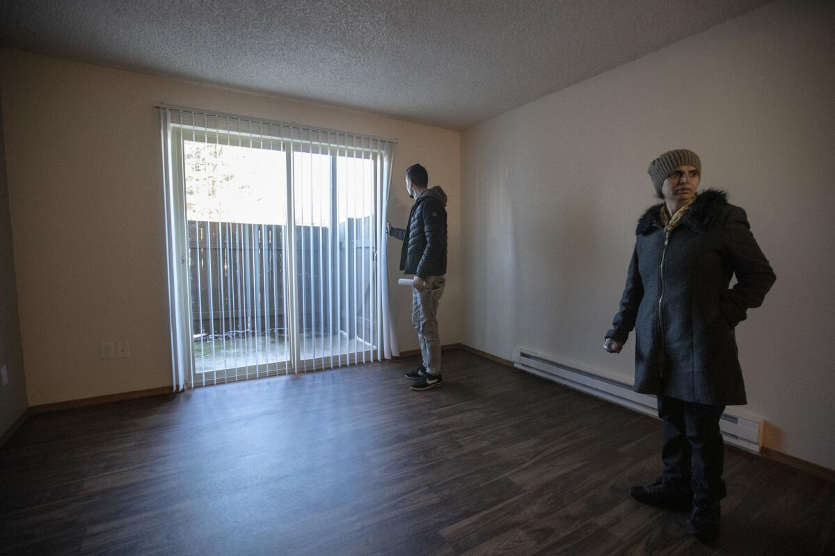 Sirvan Moradi and Saltanat Moradi look at their new apartment before signing a lease in Kent, Wash.