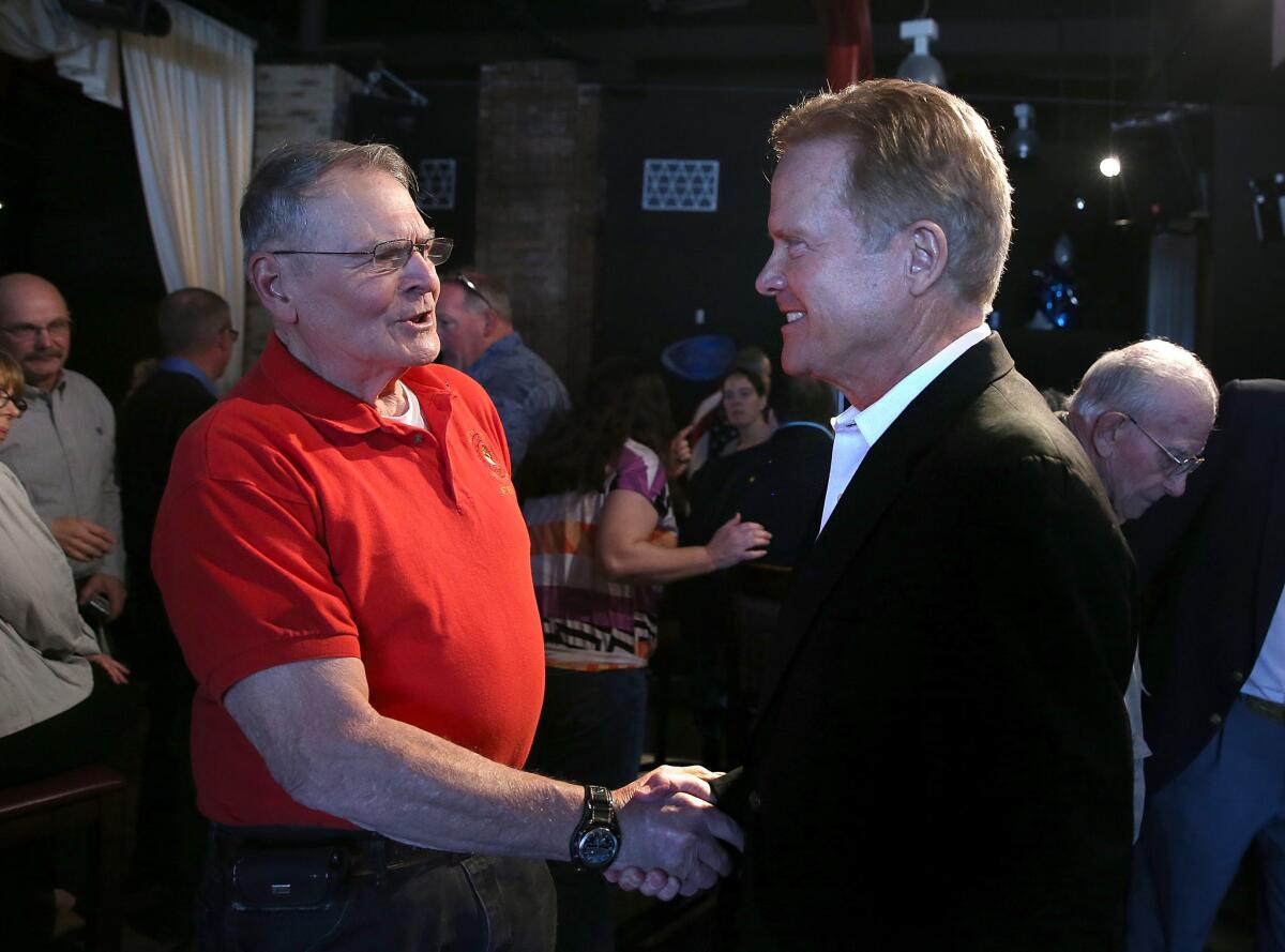 Former U.S. Sen. Jim Webb (right) greets an attendee during a fundraiser for Iowa House Democrats on April 12 in Mason City, Iowa. The former senator is considering a run for president.