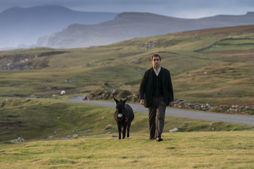 A man walks on a hilly Irish road with his donkey: Colin Farrell in "The Banshees of Inisherin"