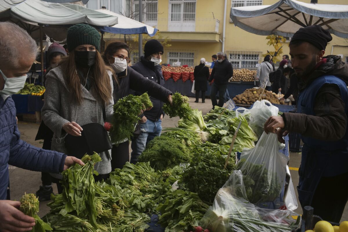 FILE - People buy food at an open air market in Ankara, Turkey, on Dec. 5, 2021. Annual inflation in Turkey hit 73.5% in May, 2022, the highest rate since 1998, according to official data released Friday, June 3, 2022, as a cost-of-living crisis in the country deepens.(AP Photo/Burhan Ozblici, File)