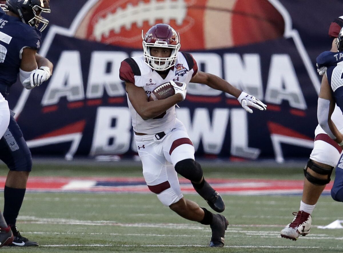 FILE - New Mexico State running back Larry Rose III (3) carries the ball in the second half during the Arizona Bowl NCAA college football game against Utah State in Tucson, Ariz., in this Friday, Dec. 29, 2017, file photo. The Arizona Bowl recently announced a partnership with Barstool Sports for its Dec. 31 game in Tucson, Arizona. The multiyear deal with the digital sports platform — notable for its occasional off-color humor and brash founder Dave Portnoy — not only includes naming rights but also broadcasting rights, which means the game won't be on ESPN or CBS. (AP Photo/Rick Scuteri, File)