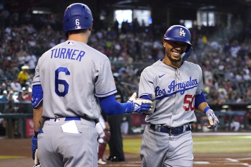 The Dodgers' Mookie Betts is greeted by Trea Turner after Betts led off the game with a home run May 28, 2022.
