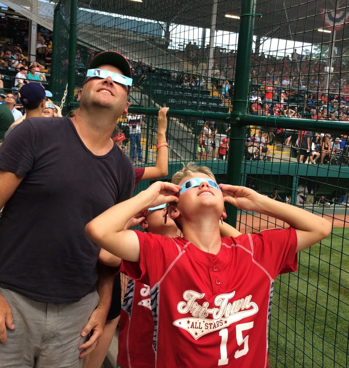 Mike Wenzel and sons Kyke and A.J. of New Jersey check out the solar eclipse between games at the Little League World Series in South Williamsport, Pa. on Monday.