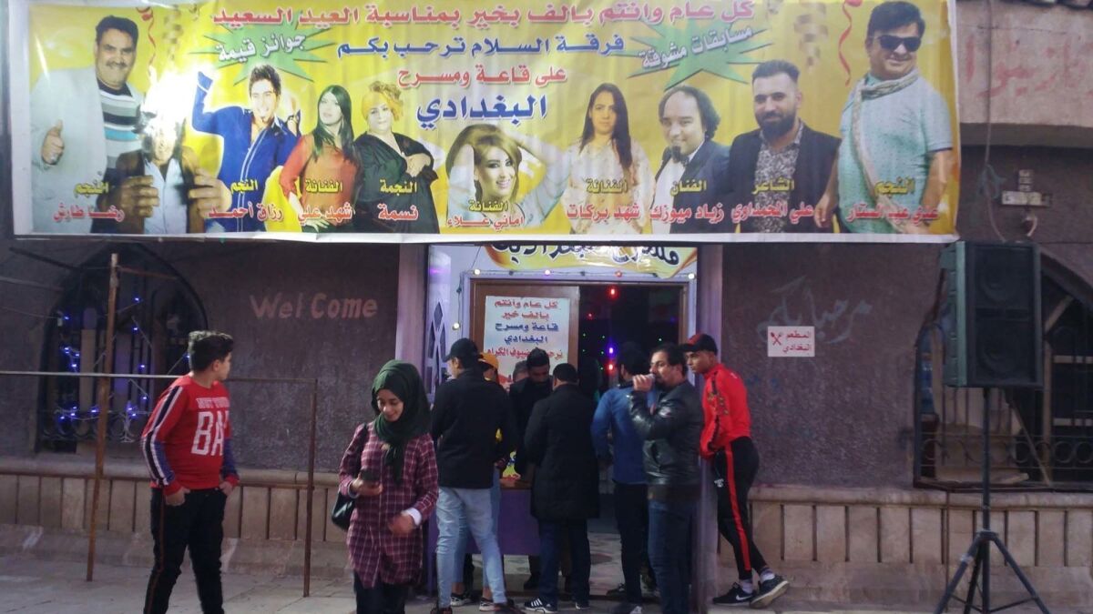 A comedian exhorts passers-by to attend a show. Baghdad is known for its theaters.