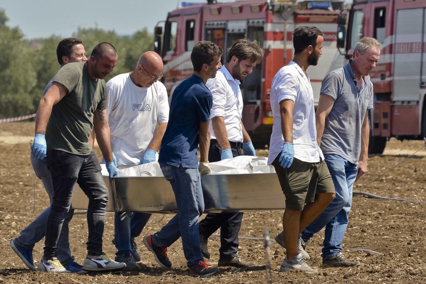 Rescuers carry a body they recovered from the scene of a train accident, after two commuter trains collided head-on near the town of Andria, in the southern region of Puglia, killing several people, Tuesday, July 12, 2016.
