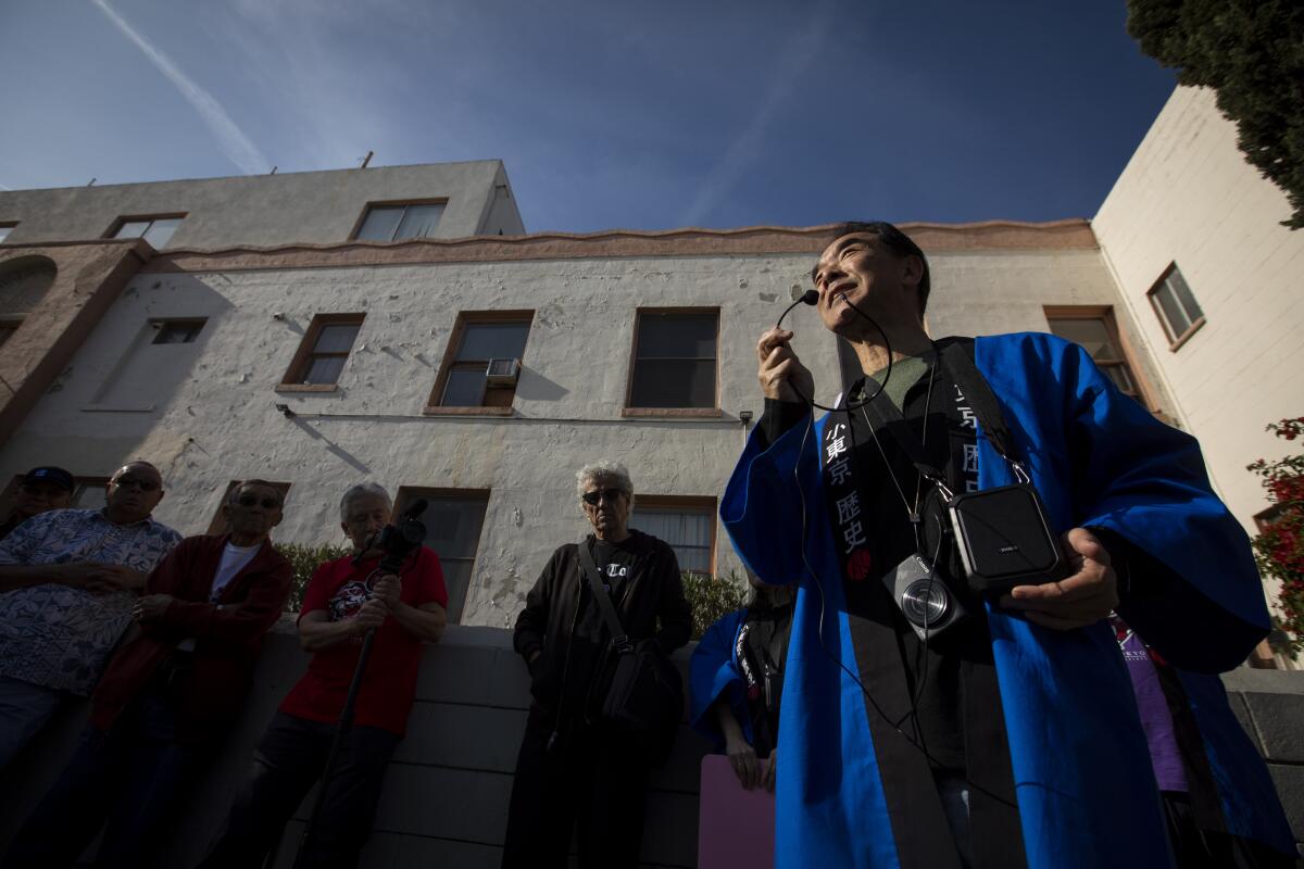 Michael Okamura speaks into a microphone