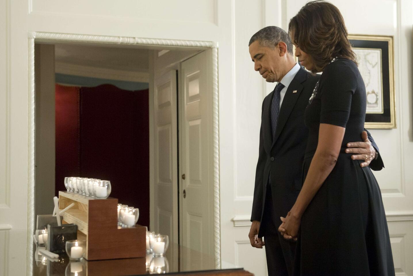 President Obama and First Lady Michelle Obama observe a moment of silence honoring the 26 students and teachers killed at Sandy Hook Elementary School in Newtown, Conn.