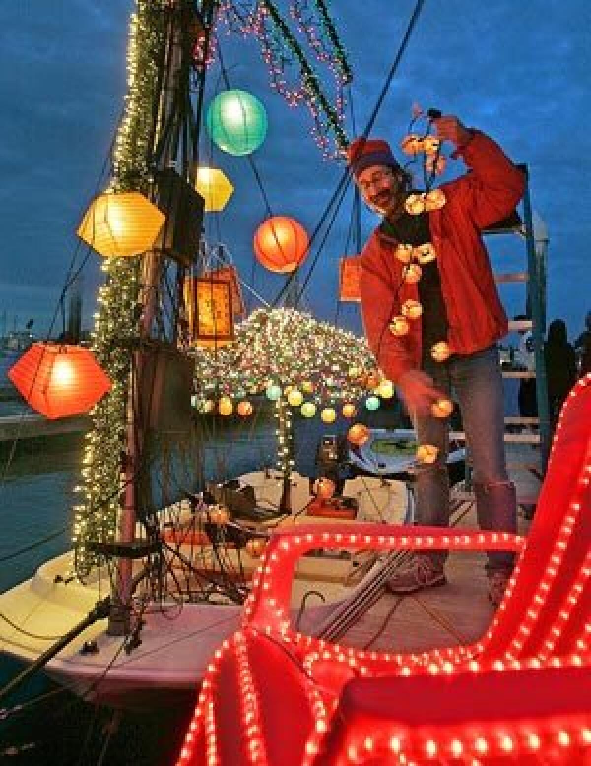 Skipper Peter Barbour strings lights on his boat in preparation for the Newport Beach Christmas boat parade.