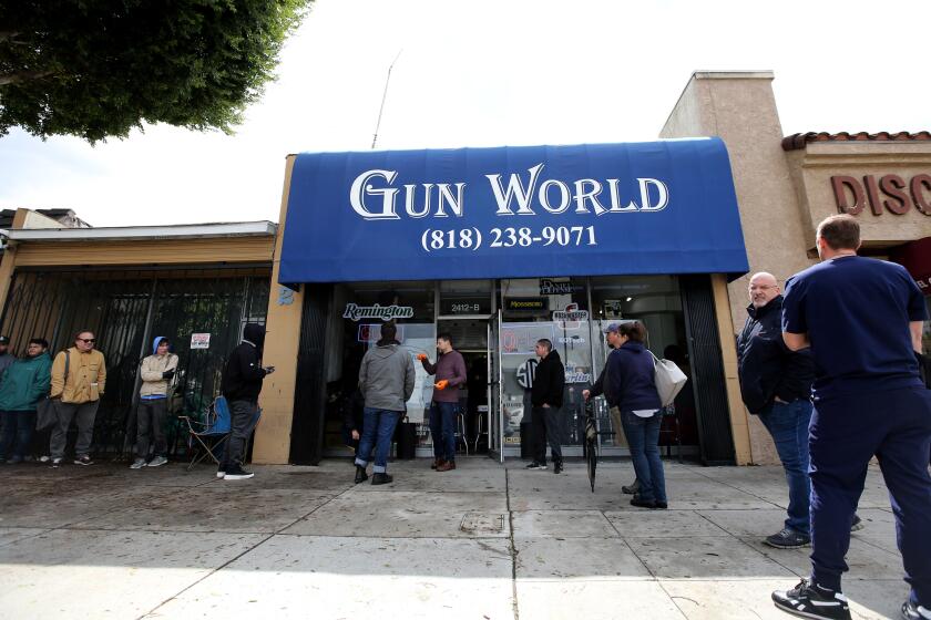 Customers line up outside Gun World on Magnolia Ave. in Burbank on Tuesday, March 17, 2020. Some were purchasing ammunition and others guns.
