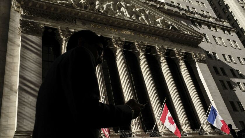 A man walks past the New York Stock Exchange.