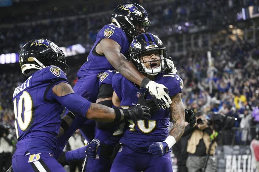 Baltimore Ravens punt returner Tylan Wallace, right, celebrates with teammates after a punt return.