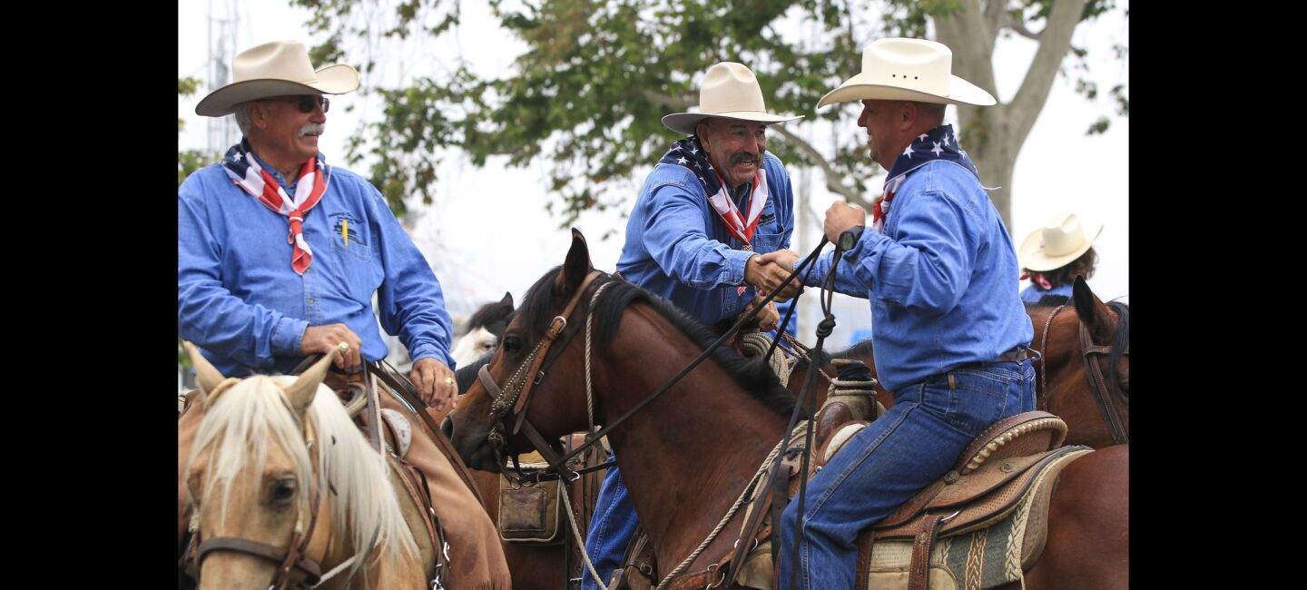 Cowboys shake hands after they completed a cattle drive to promote the San Diego County Fair.