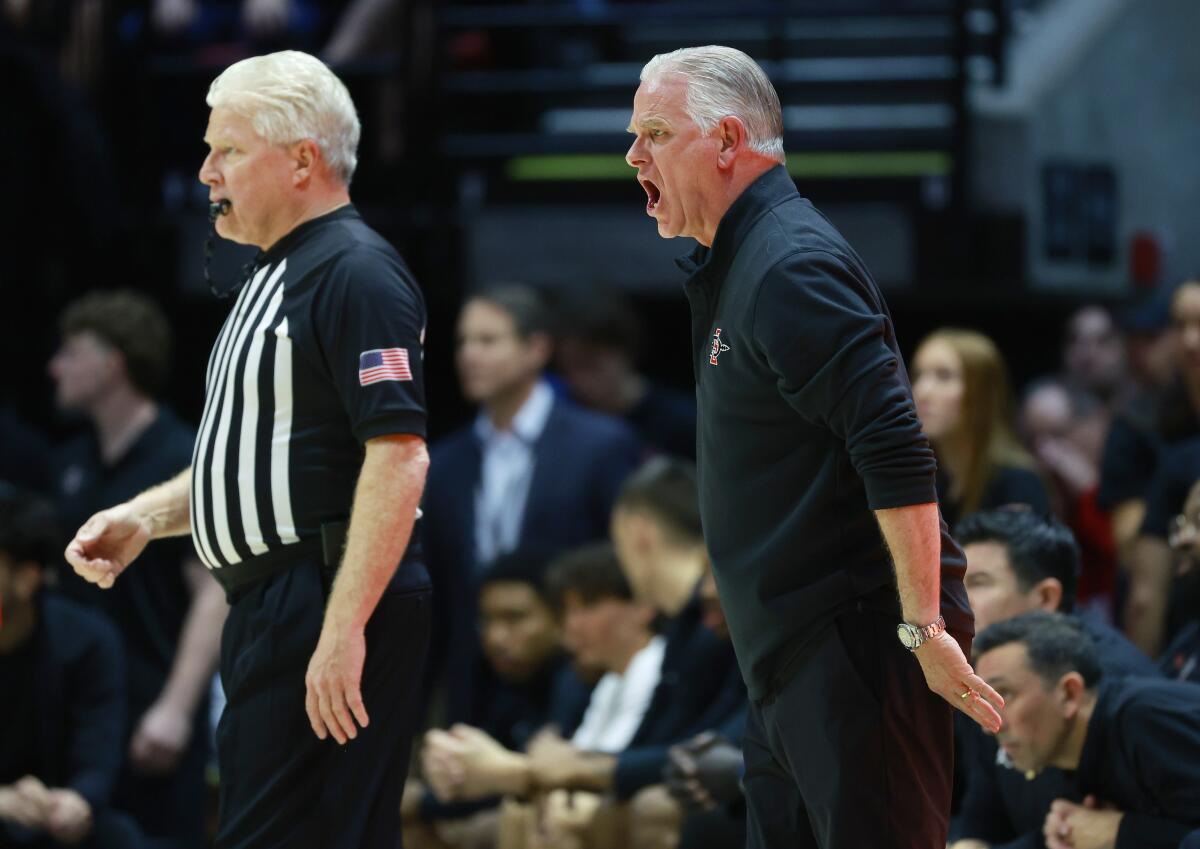 SDSU coach Brian Dutcher argues a call with official Eric Curry during a Feb. 16 game against New Mexico at Viejas Arena.