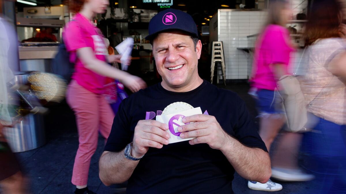 Umami Burger founder Adam Fleischman, with a peanut butter and jelly sandwich, at Grand Central Market in Los Angeles.