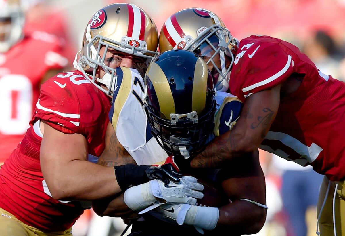 Rams running back Tre Mason is tackled by 49ers Antoine Bethea, right and Chris Borland during a November 2014 game.