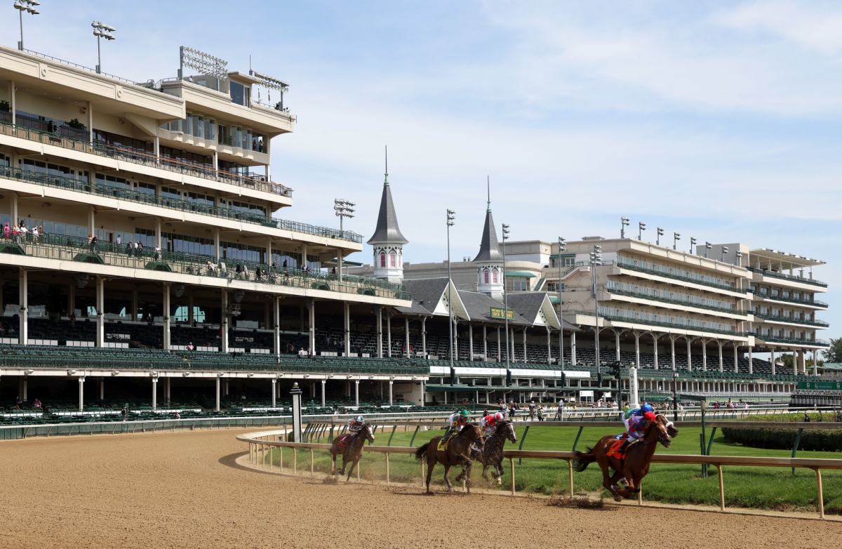 Empty grandstands as horses run around the Churchill Downs track