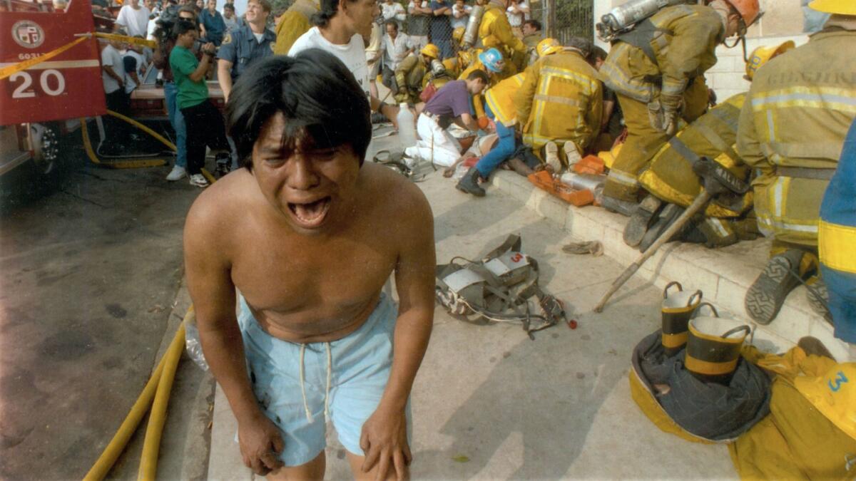 A young man weeps after seeing a dead child outside an apartment house on Burlington Avenue.