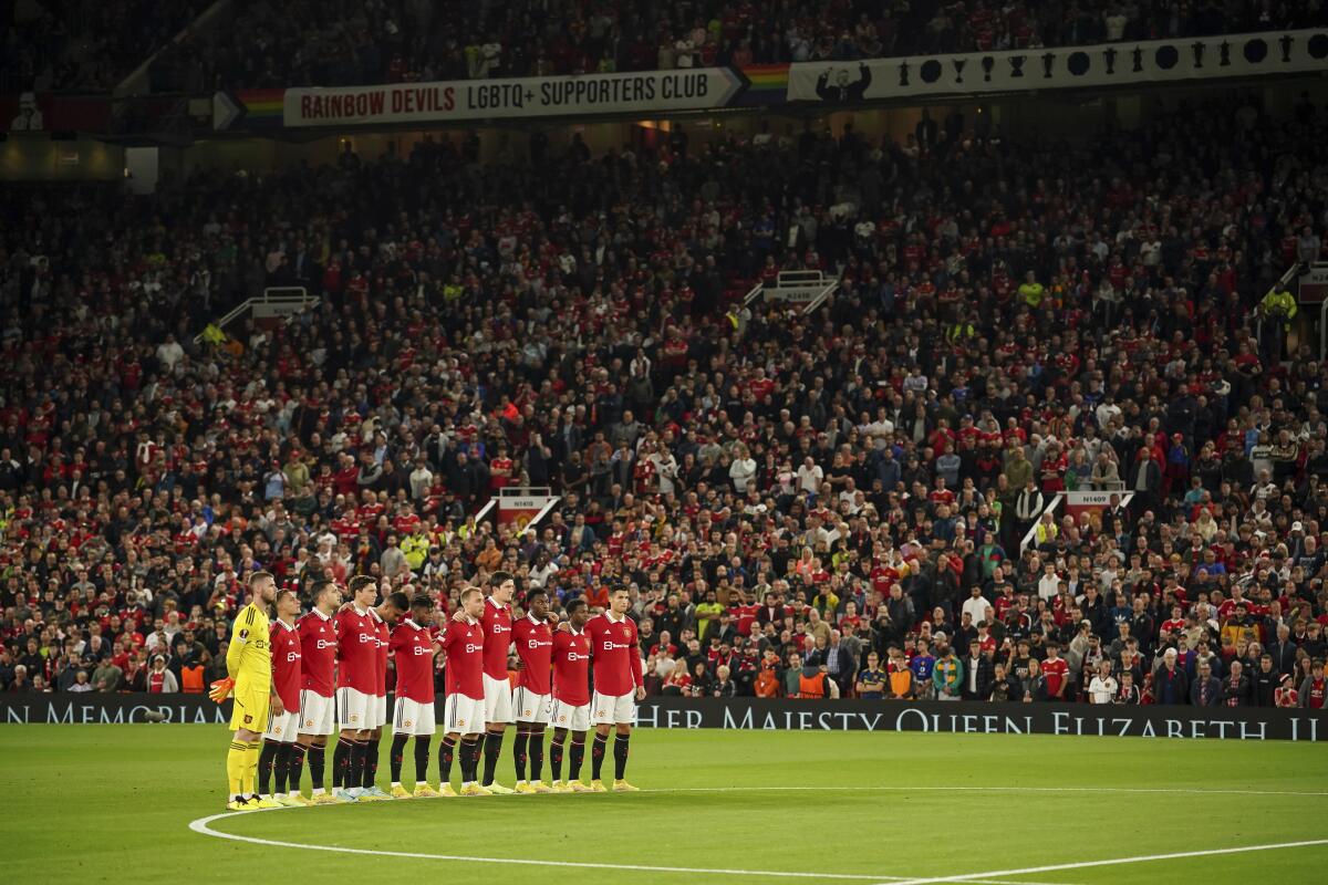 Manchester United players observe a minutes silence following the death of Queen Elizabeth II, ahead of the group E Europa League soccer match between Manchester United and Real Sociedad at Old Trafford in Manchester, England, Thursday, Sept. 8, 2022. (AP Photo/Dave Thompson)