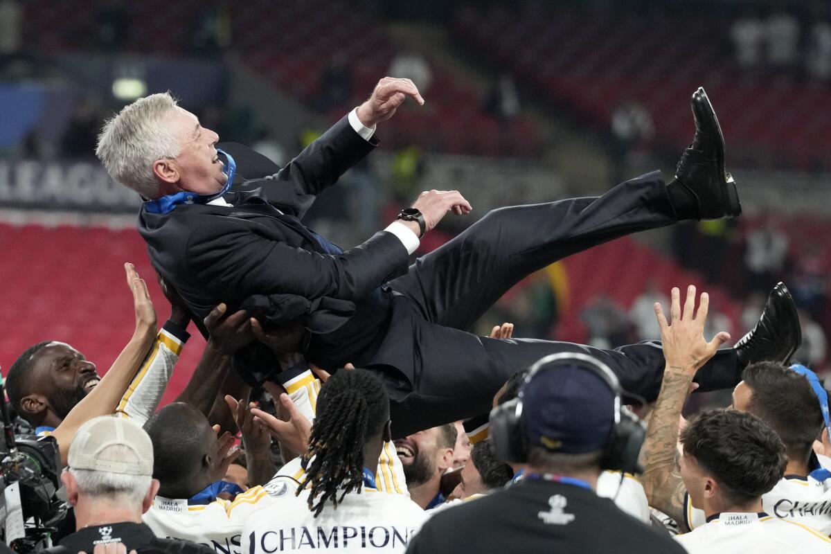 Real Madrid players throw head coach Carlo Ancelotti in the air after beating Borussia Dortmund in the Champions League final