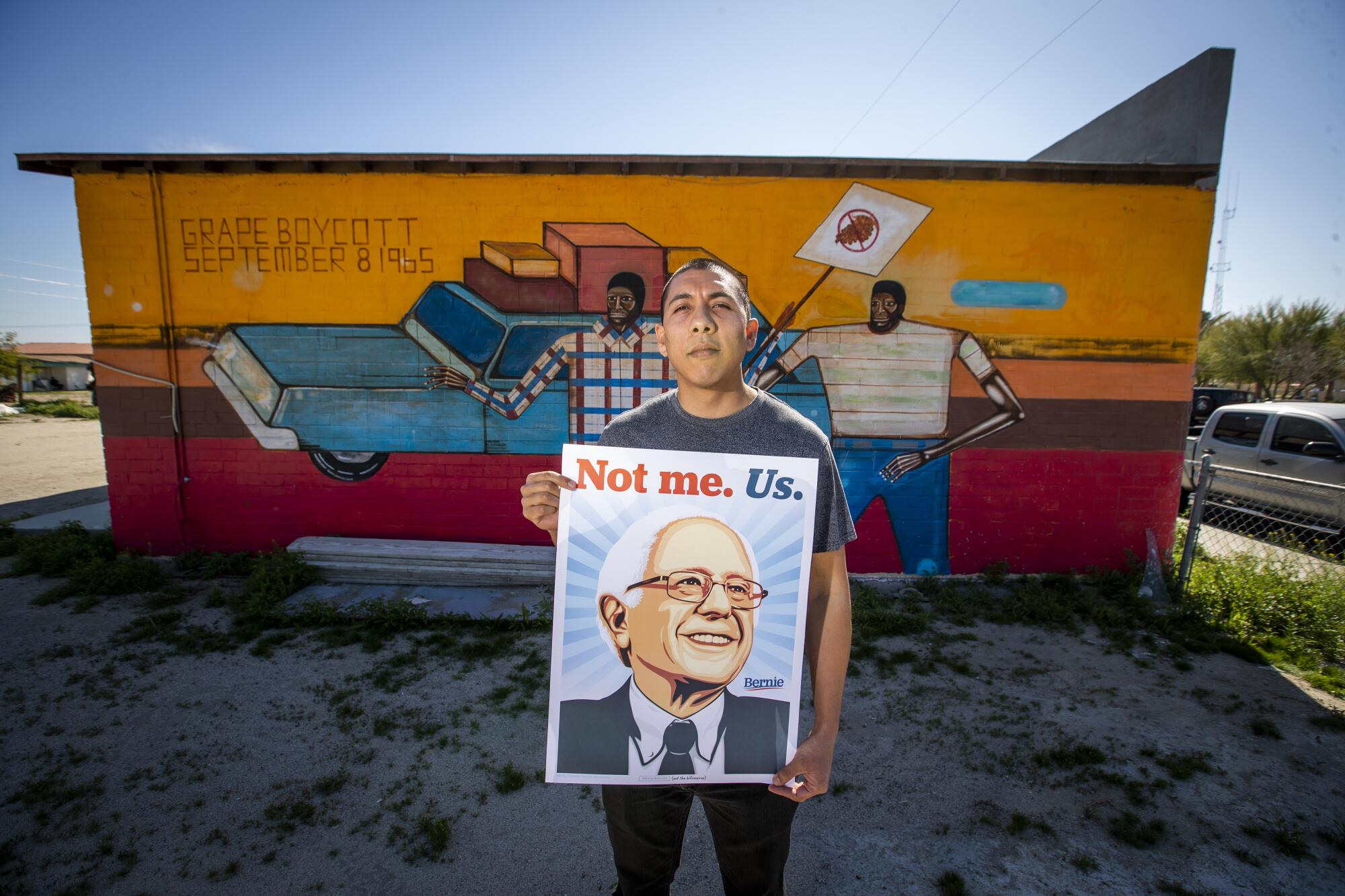 Indio Councilman Oscar Ortiz, 31, holds a sign at the Coachellla Valley's Bernie Sanders campaign headquarters, where he serves as the field organizer.