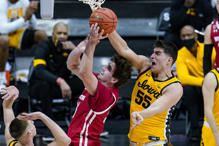 Iowa center Luka Garza (55) blocks the shot of Wisconsin forward Nate Reuvers (35) in the first half of an NCAA college basketball game at the Big Ten Conference men's tournament in Indianapolis, Friday, March 12, 2021. (AP Photo/Michael Conroy)
