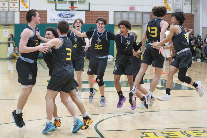 The Marina boys varsity basketball team jump out onto the court after winning the CIF Southern Section Division 2A title against Long Beach Poly on Saturday at Edison High.