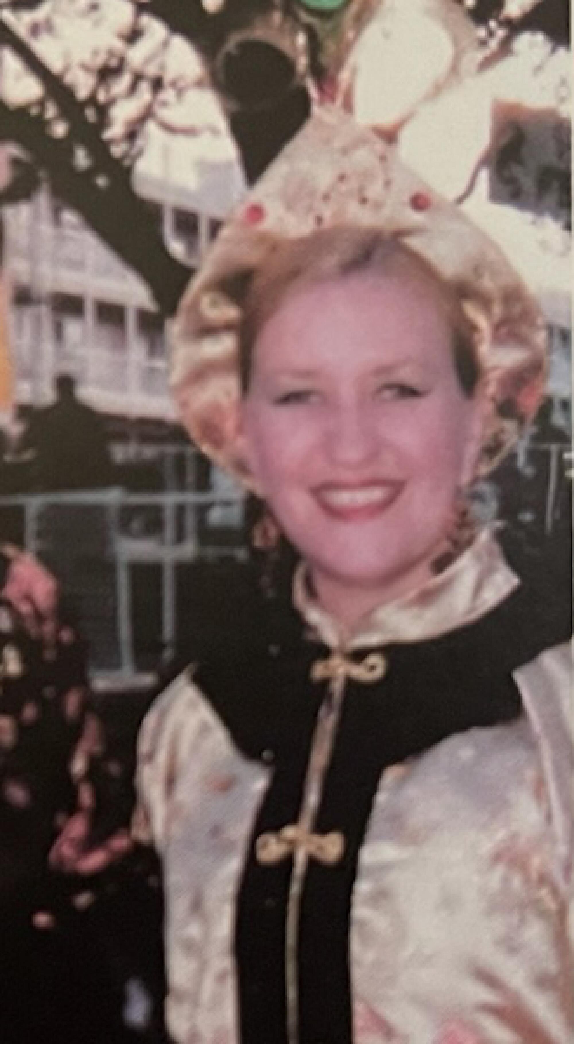 A white woman pictured from the chest up, wearing a Chinese-inspired costume and dark eye makeup that comes to a point.