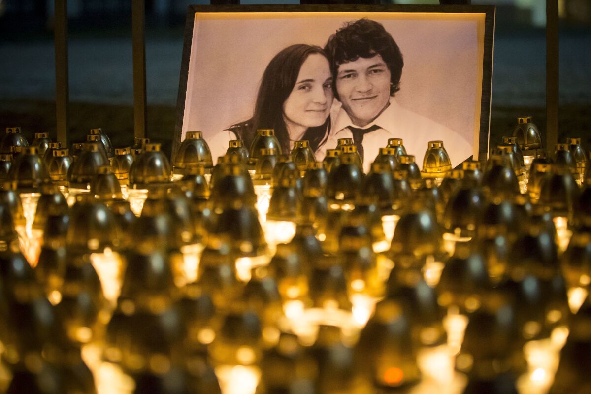 FILE - In this Wednesday, Feb. 28, 2018 file photo, light tributes are seen during a silent protest in memory of murdered journalist Jan Kuciak and his girlfriend Martina Kusnirova, seen in photo, in Bratislava, Slovakia. A court in Slovakia is expected to issue a verdict on Thursday Sept. 3, 2020, in the slayings of an investigative journalist and his fiancee, a crime that shocked the country and led a government to fall. (AP Photo/Bundas Engler, file)