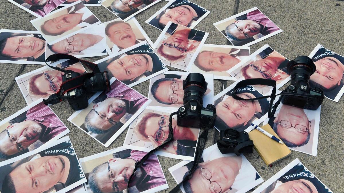 Cameras and photos of journalists killed across Mexico are placed on the ground during a May 2017 protest in Mexico City.