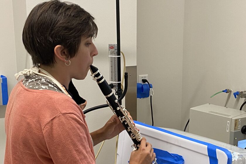 Researcher Tehya Stockman plays a clarinet in a University of Colorado Boulder lab to measure aerosol output.