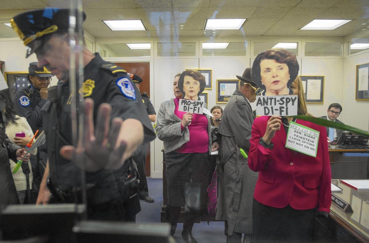 A Capitol Police officer closes the door to the office of Sen. Dianne Feinstein, chair of the Senate Intelligence Committee, as demonstrators approach to protest her stance on CIA activities.