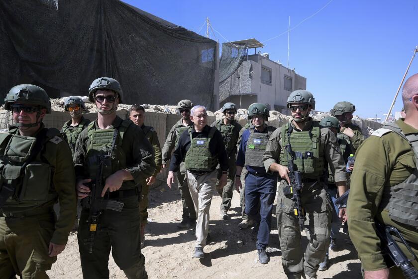 Israel's Prime Minister Benjamin Netanyahu, center, walks with Israeli forces during a surprise visit to the southern city of Rafah in the Gaza Strip, Thursday, July 18, 2024. (Avi Ohayon/Israel Prime Minister's Office via AP)