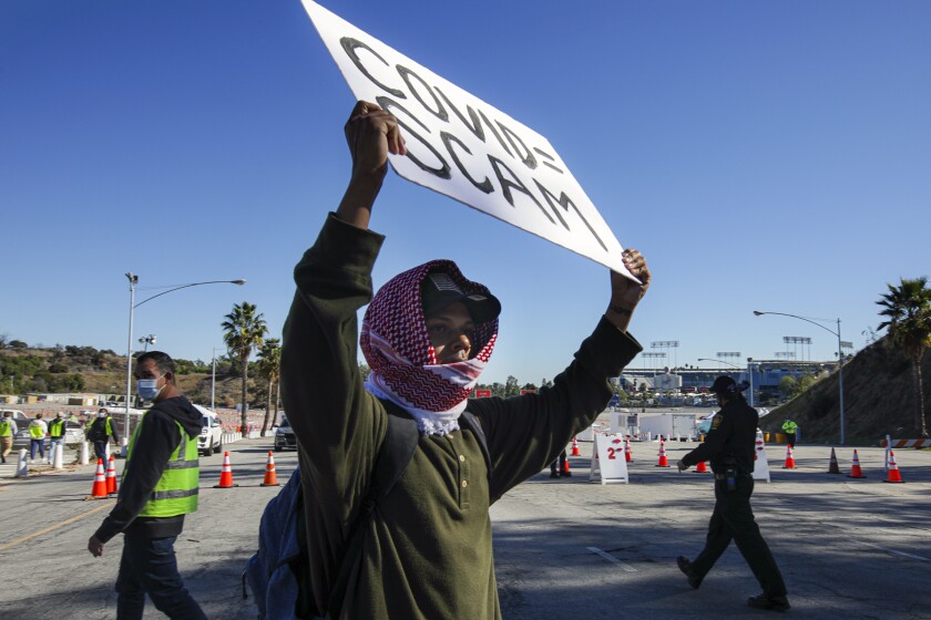 A man protests in front of the closed gates to the vaccination site at Dodger Stadium on Jan. 30. 