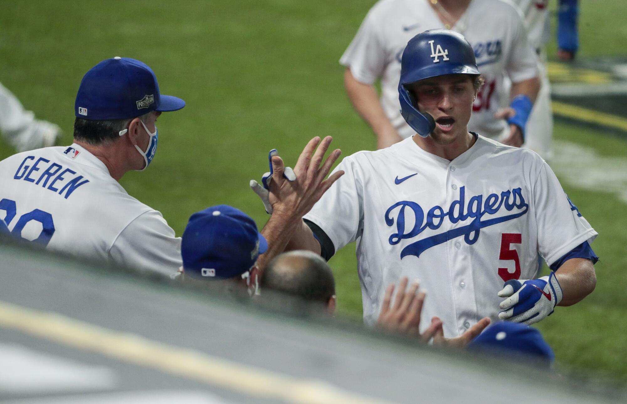 Dodgers shortstop Corey Seager is congratulated by bench coach Bob Geren after hitting a three-run home run.
