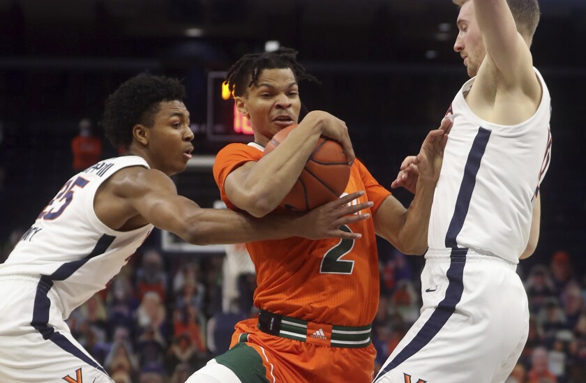 Miami guard Isaiah Wong (2) is pressured by Virginia guard Trey Murphy III (25) and forward Sam Hauser, right, during an NCAA college basketball game Monday in Charlottesville, Va. (Andrew Shurtleff/The Daily Progress via AP, Pool)