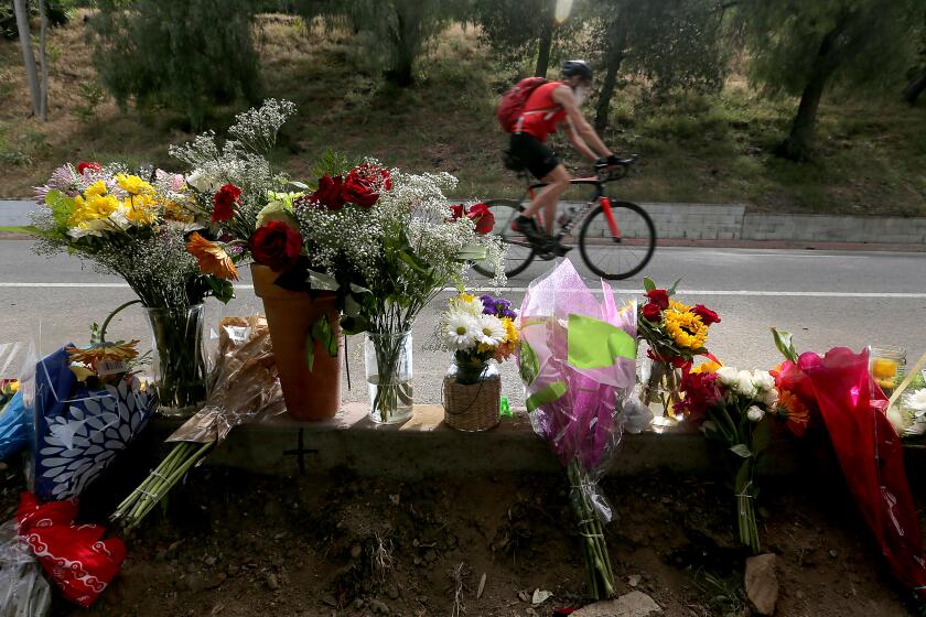 LOS ANGELES, CALIF. - APR. 18, 2022. Flowers mark the location where bicyclist Andrew Jelmert, 77, was killed after being struck by a vehicle while participating in the AIDS/LifeCycle charity ride in Griffith Park on Saturday, Apr. 16,. 2022. The Los Angeles Police Department has arrested the driver who was booked on suspicion of gross vehicular manslaughter. Police said the driver left the scene without providing aid or identifying himself. (Luis Sinco / Los Angeles Times)