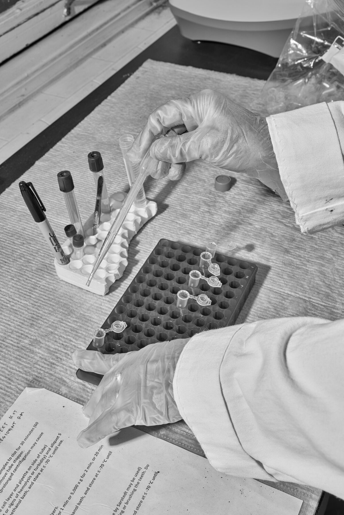A researcher uses pipettes to transfer material into tubes for testing.