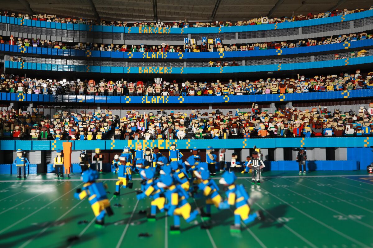 Lego figurines appear to play football in a miniature replica of SoFi Stadium. 