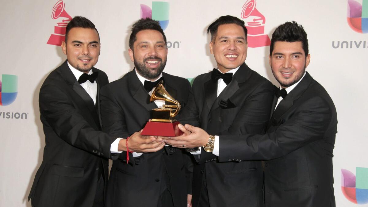 Members of Banda El Recodo de Cruz Lizarraga pose with their Latin Grammy for best banda album.