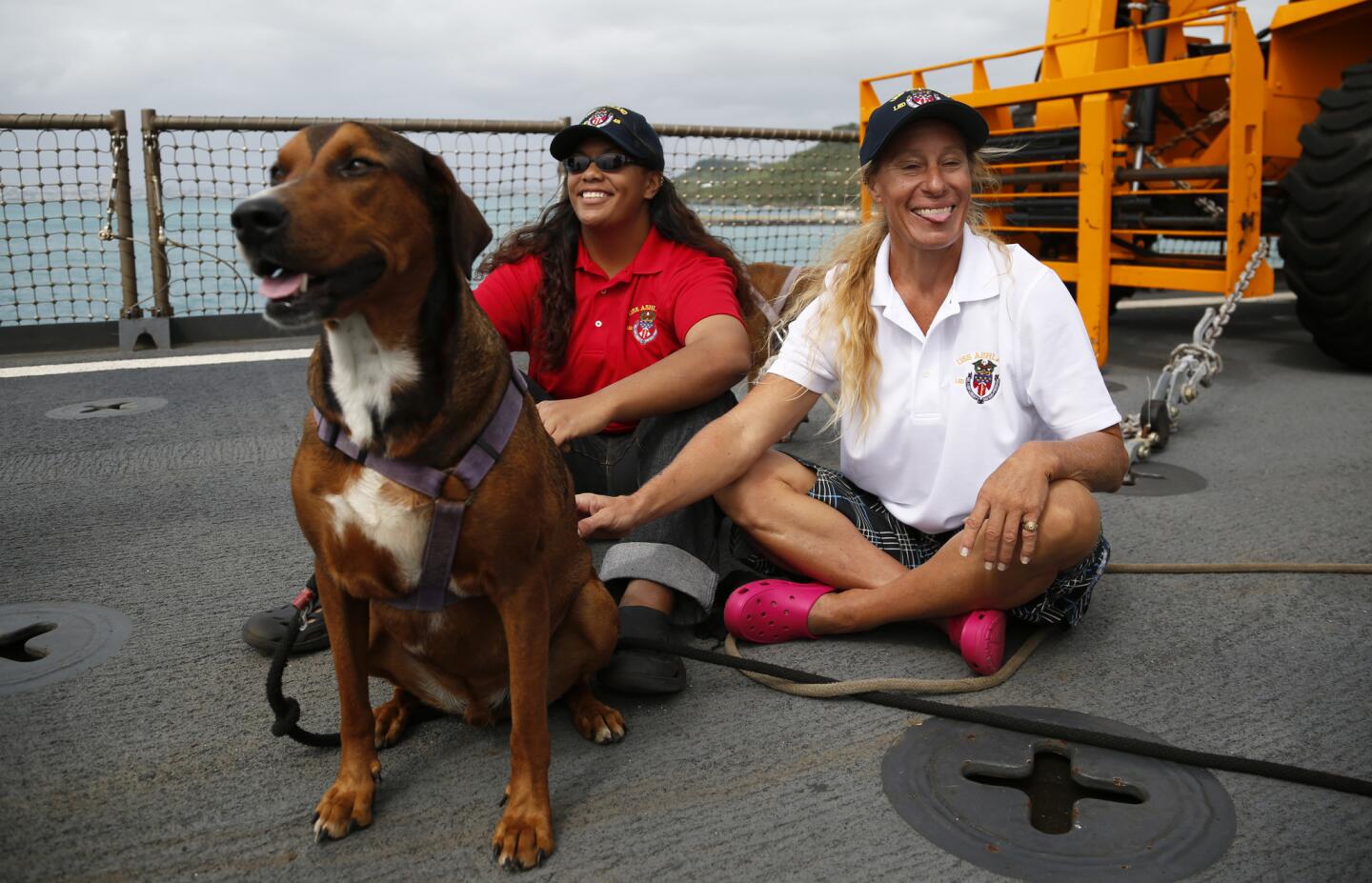Jennifer Appel, right, and Tasha Fuiava sit with their dogs on the deck of the USS Ashland on Oct. 30, 2017, at White Beach Naval Facility in Okinawa, Japan.