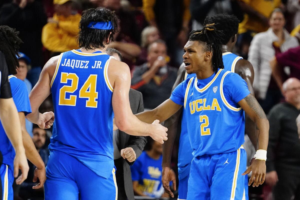 UCLA's Jamie Jaquez Jr. is greeted by Dylan Andrews after hitting a three-pointer against Arizona State.